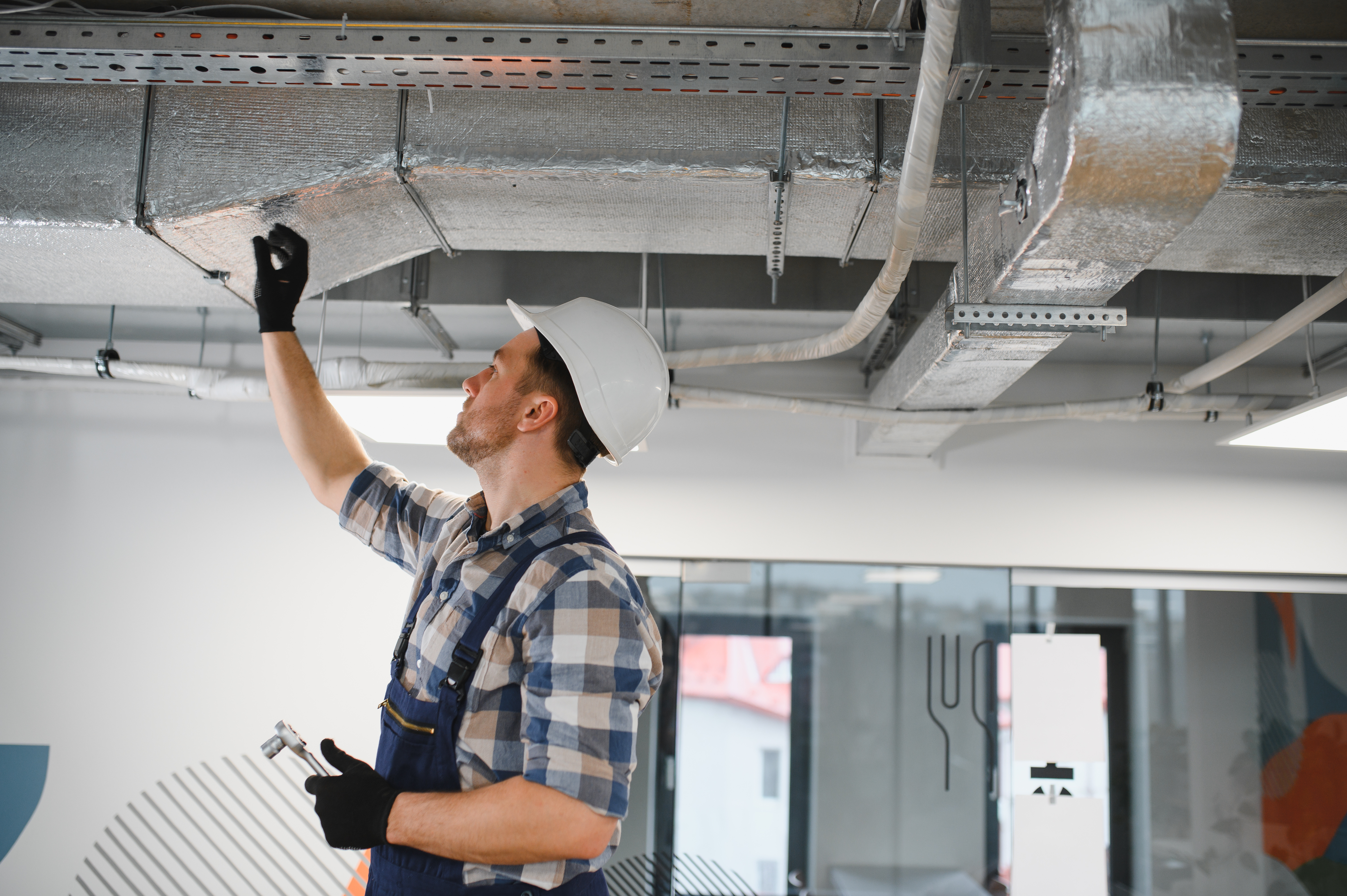 A certified ESCO technician servicing a commercial HVAC unit, highlighting heating and AC repair expertise.